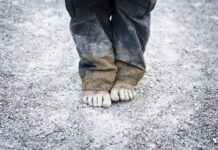 Млада майка проси заедно с невръстното си дете в студа на тротоара между автогарата и гарата